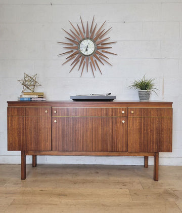 Petite refinished sideboard with updated hardware, brass trim, and removable shelves, styled with decor and starburst clock.