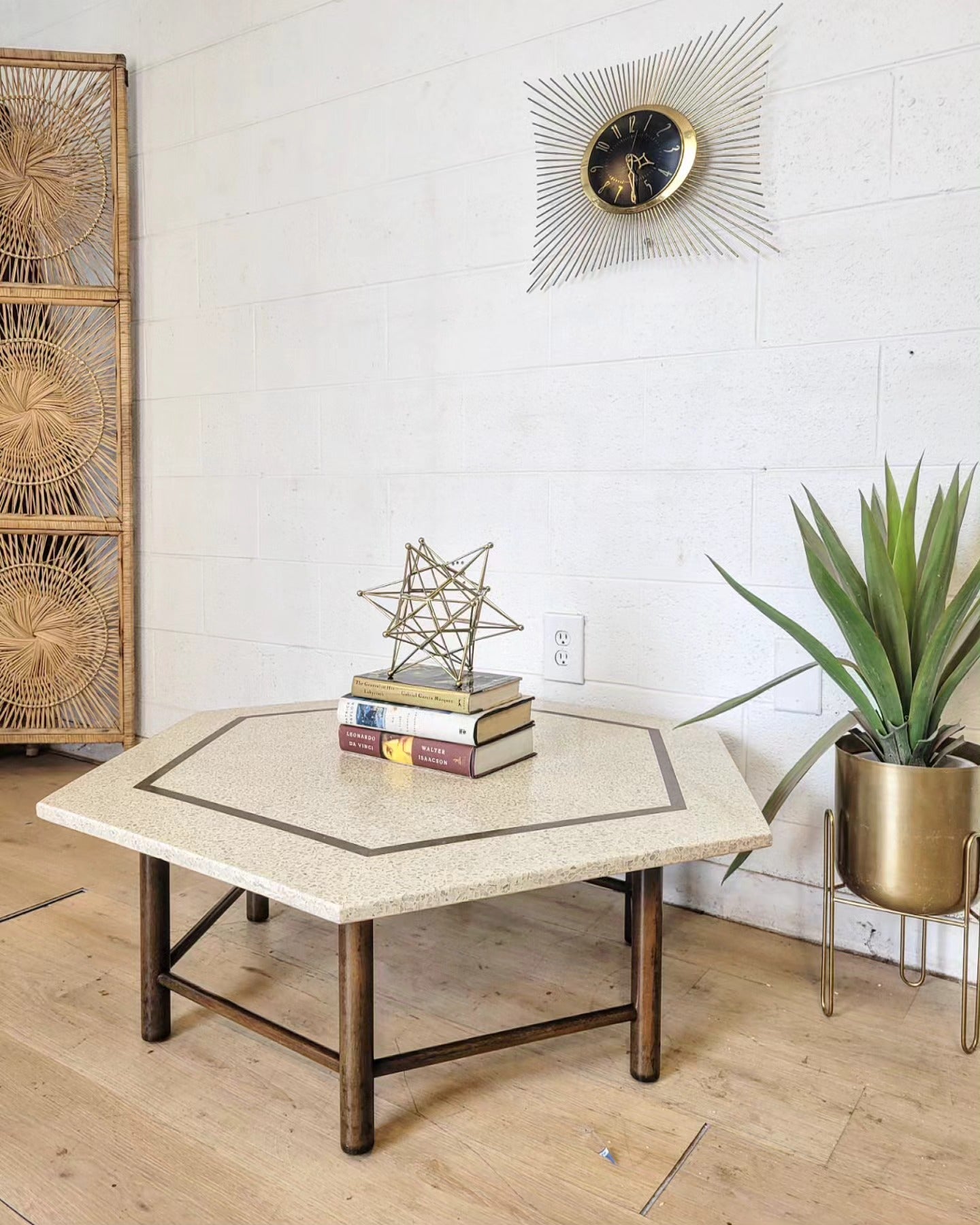 Harvey Probber hexagon coffee table with travertine top and mahogany base, styled with books and decor in a modern living room setting.