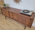 RHF Credenza with teak grain and atomic design, featuring adjustable shelves and tapering sides, styled with a turntable on top.