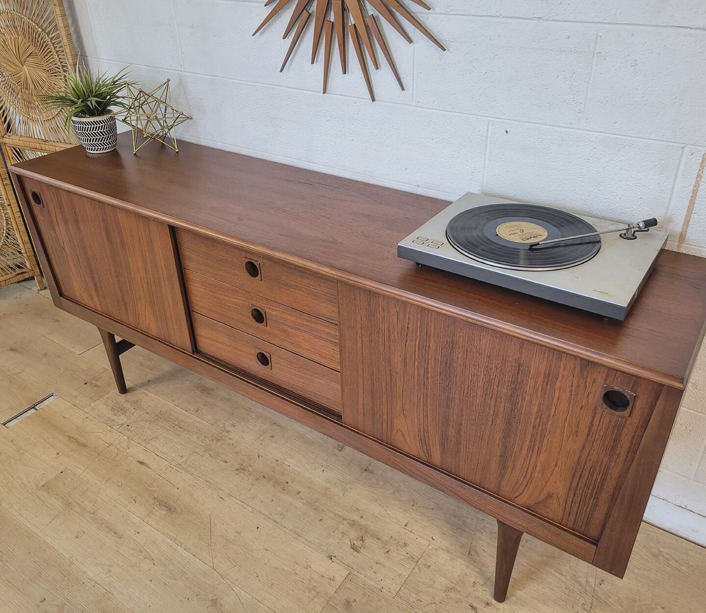 RHF Credenza with teak grain and atomic design, featuring adjustable shelves and tapering sides, styled with a turntable on top.