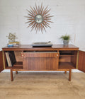 Petite refinished sideboard with updated hardware, original brass trim, and removable shelves, styled with decor and a clock.