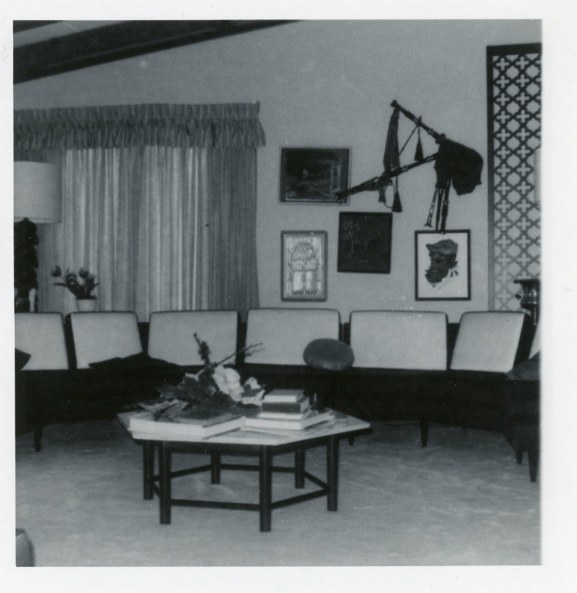 Vintage photo of a Harvey Probber travertine hexagon coffee table with a solid mahogany base in a mid-century modern living room.