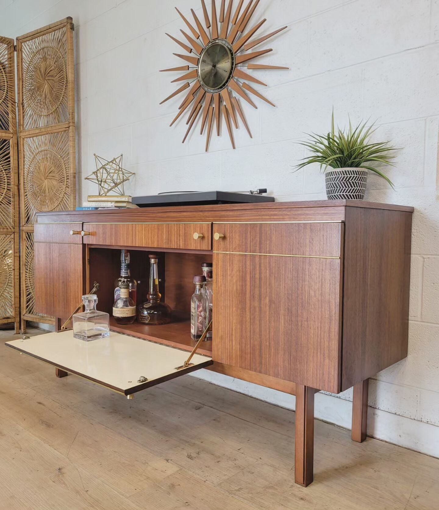 Petite refinished sideboard with updated hardware, original brass trim, and removable shelves, styled with decor and plants.